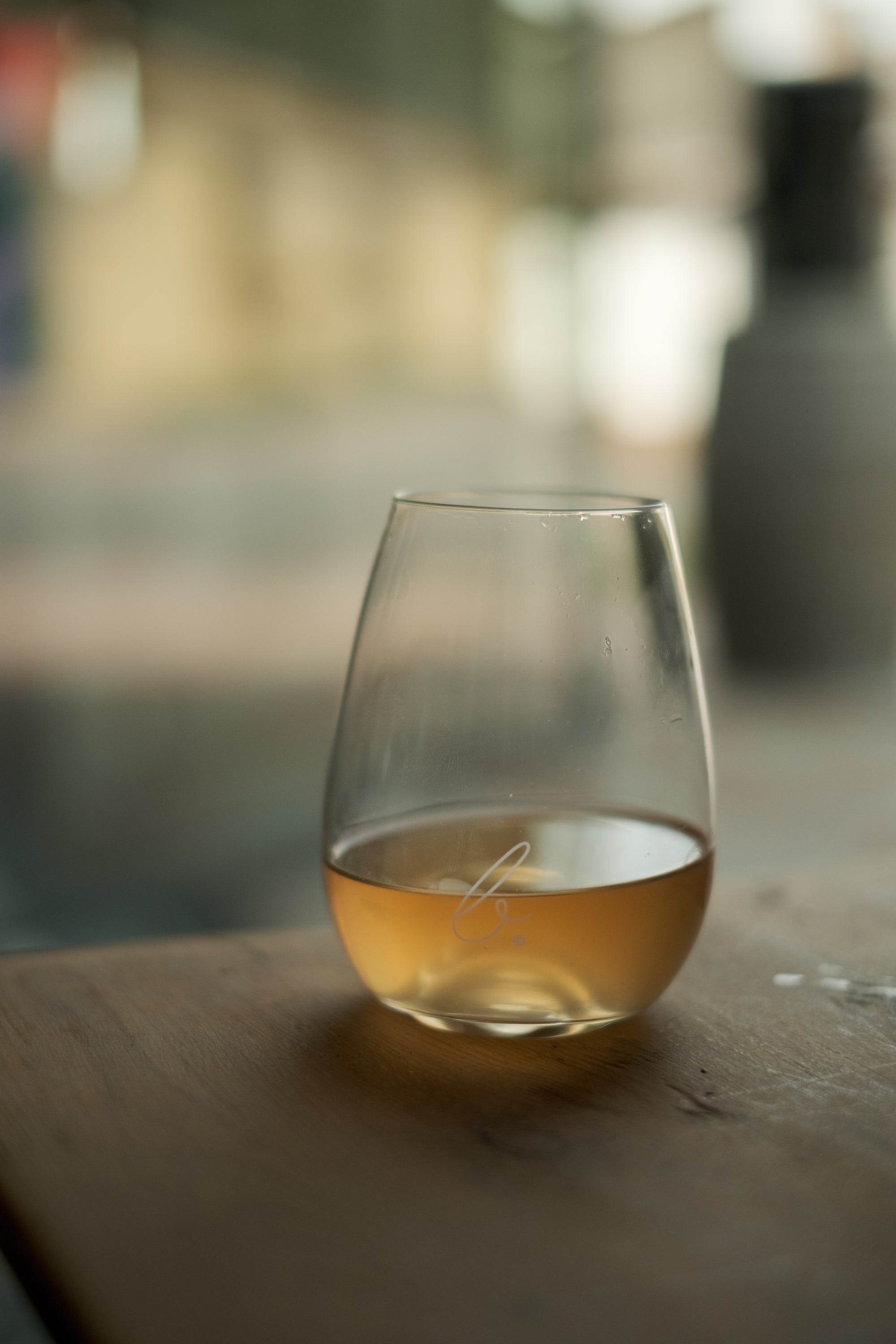 Wine glass with Gilvesy organic wine on table with b-üzem logo on glass.