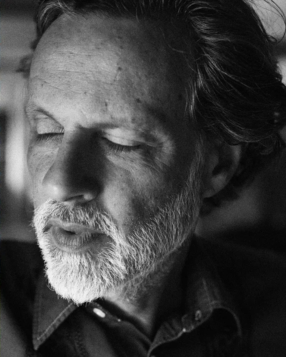 Black and white portrait of Robert Gilvesy with a beard and closed eyes.